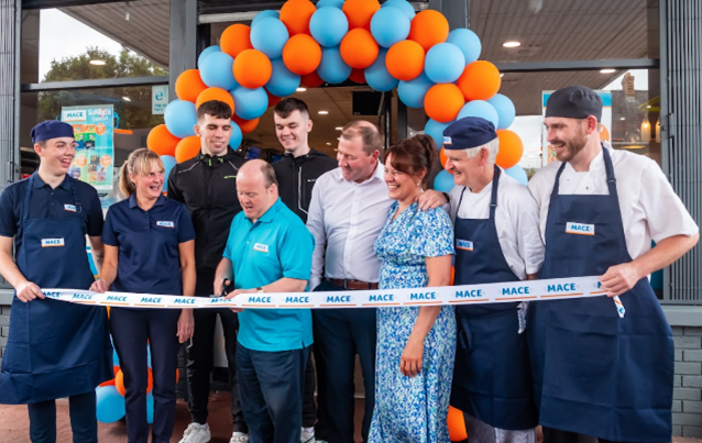 Retailers Amanda and Aidan Boyd outside MACE Smithborough with staff cutting ribbon